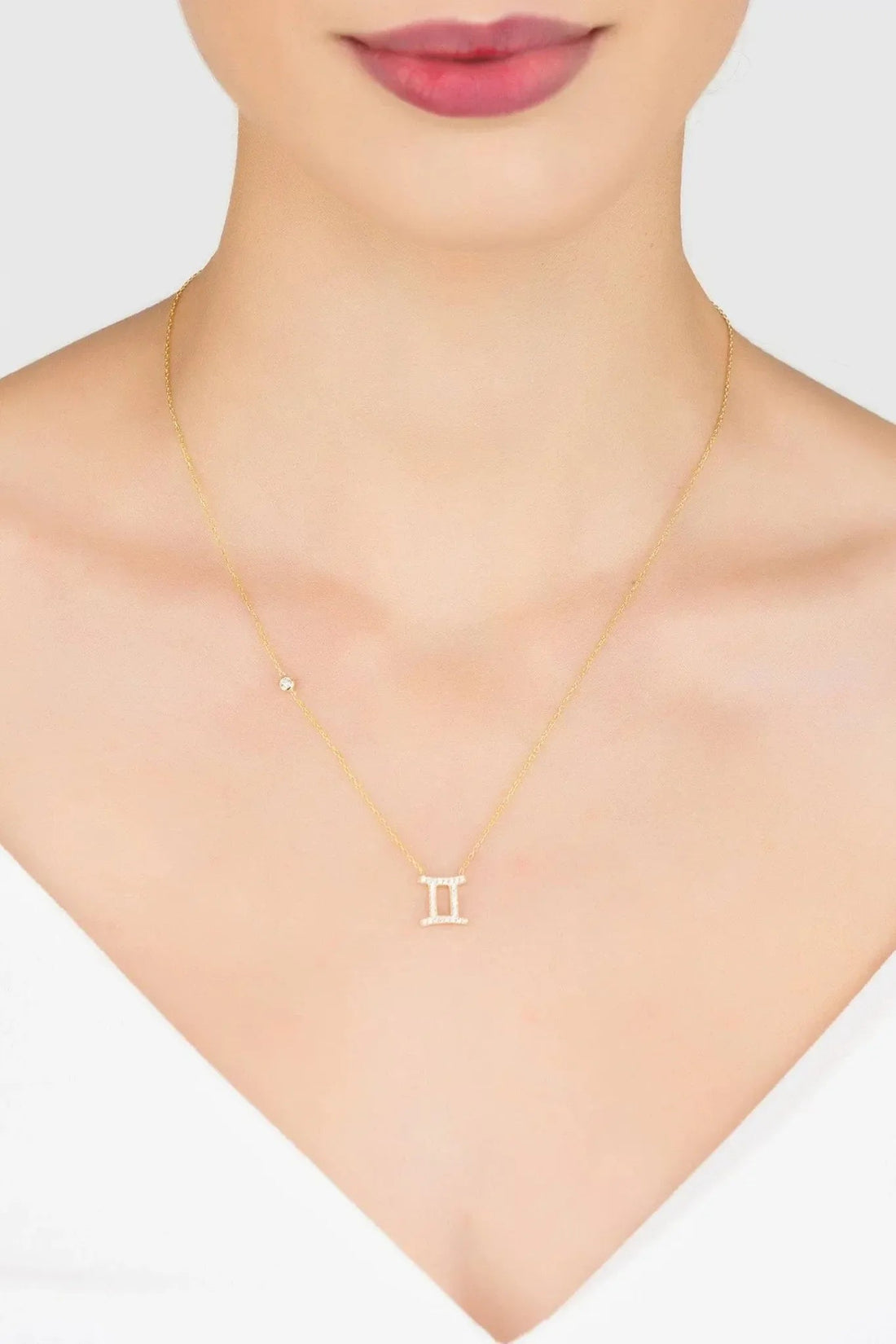 Gold Gemini zodiac pendant necklace worn on neck with thin chain