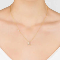 Gold zodiac pendant necklace on model with Leo symbol charm at the collar