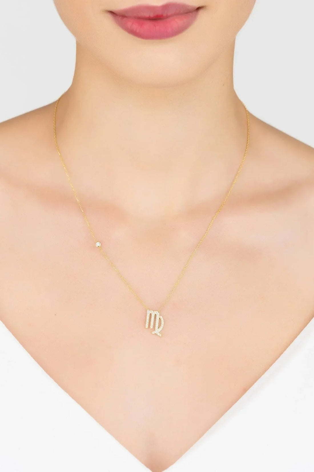 Gold zodiac pendant necklace with small Virgo symbol on chain