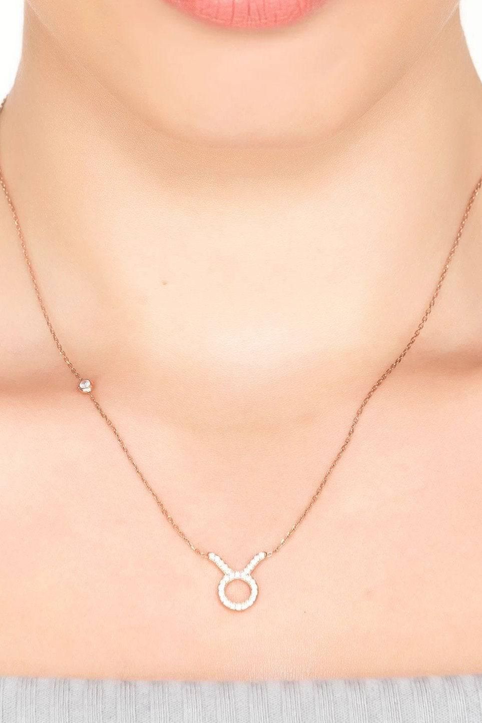 Silver-tone Taurus zodiac pendant necklace with small ring pendant on fine chain